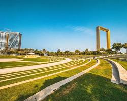 مساحات خضراء شاسعة في إحدى حدائق دبي العامة تظهر فيها العائلات تستمتع بالأجواء الطبيعية والهدوء.