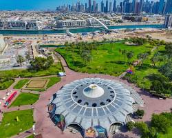 مساحات خضراء شاسعة في إحدى حدائق دبي العامة تظهر فيها العائلات تستمتع بالأجواء الطبيعية والهدوء.