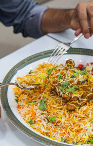 دجاج برياني تقليدي غني بالبهارات والأرز الملون في مطعم بملامح عائلي في عود ميثاء.